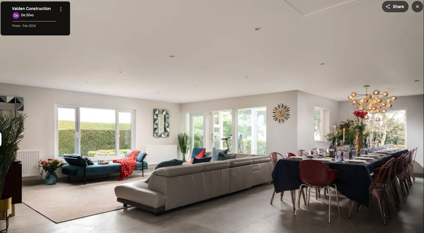 Open-plan living and dining room renovation with large windows and modern interior